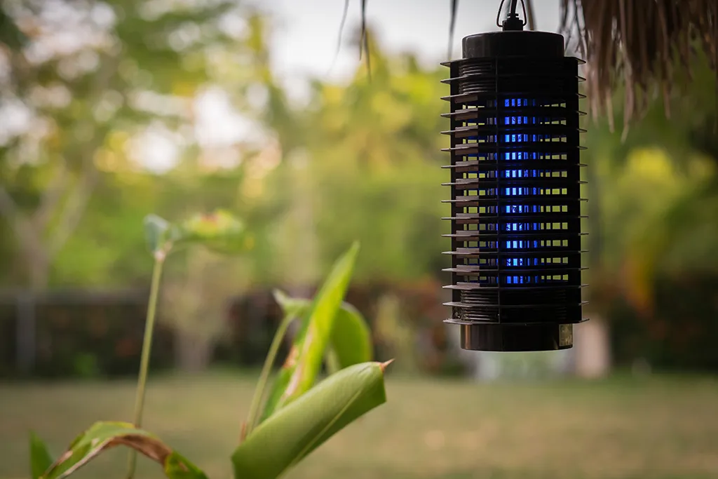 Mosquito trap hanging from a roof on a backyard patio