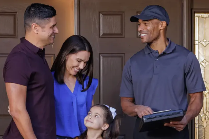 A Griffin Pest Solutions technician shows a family a quote for carpenter ant control in Michigan