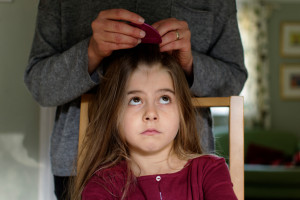 girl getting head lice inspection