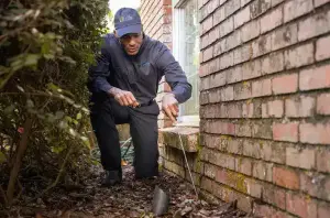 A Griffin Pest Solutions technician checks a Michigan home's foundation during an integrated pest management visit.