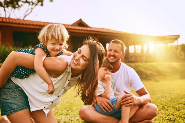 Happy family playing in a mosquito-free backyard during a sunny golden hour afternoon.